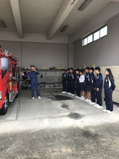 消防車の説明を聞く中学生の写真