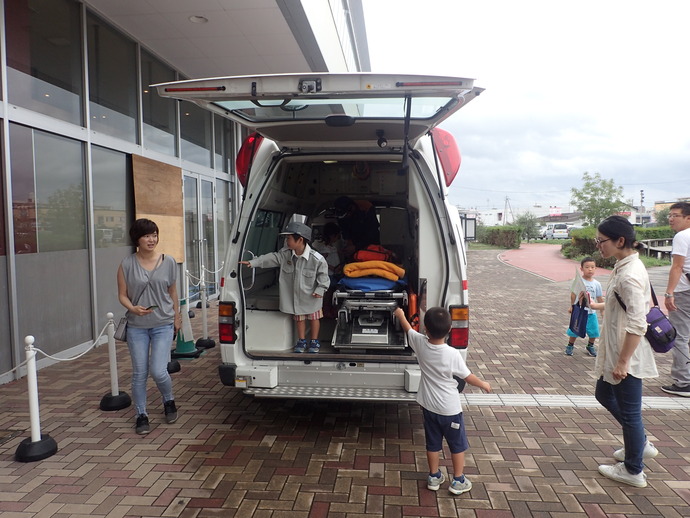 来場した子供が子供用の救急服を着て、救急車に乗車