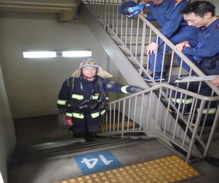 階段を上がる新人消防士