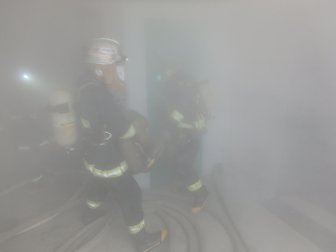 煙の中で要救助者を搬送する救助隊