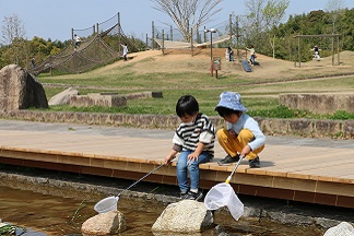 小川で遊ぶ子どもたち