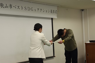 令和6年度和歌山市ベストSDGsアクション表彰式で表彰状を受け取る様子
